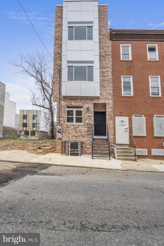 townhome / multi-family property featuring brick siding and entry steps