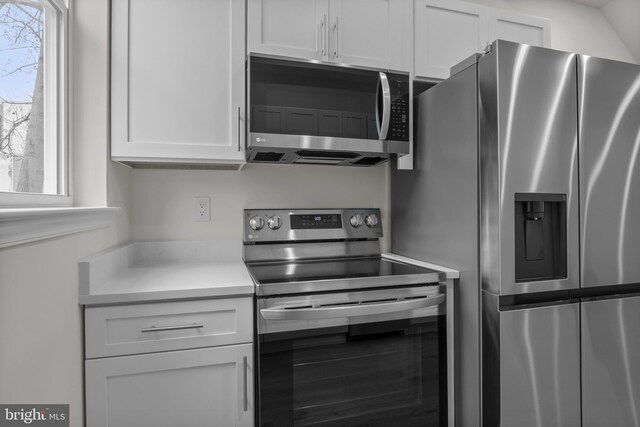 kitchen with a healthy amount of sunlight, stainless steel appliances, and white cabinets