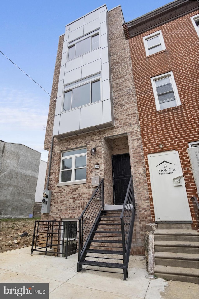 view of front of house with entry steps and brick siding