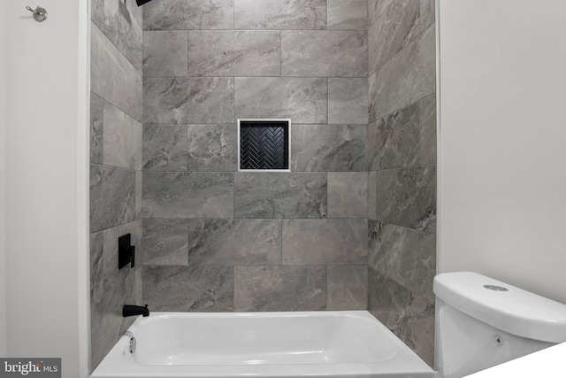 bathroom with toilet and tiled shower / bath combo