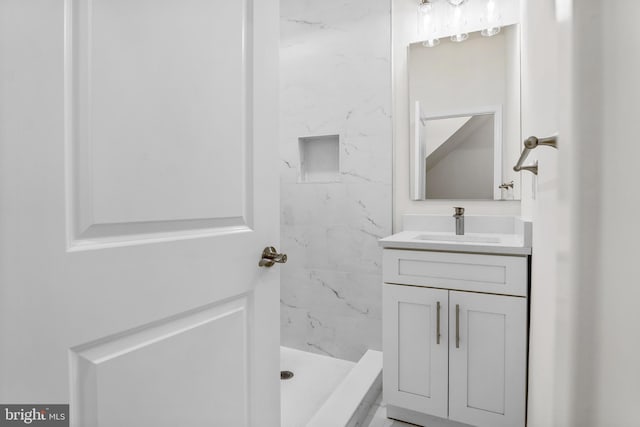 bathroom with vanity and a tile shower