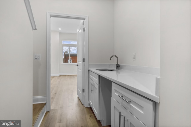 bar featuring sink and light hardwood / wood-style floors