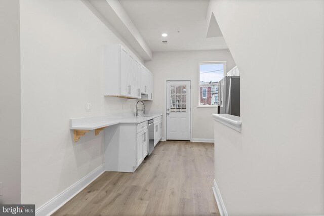 kitchen featuring light hardwood / wood-style flooring, stainless steel appliances, sink, and white cabinetry