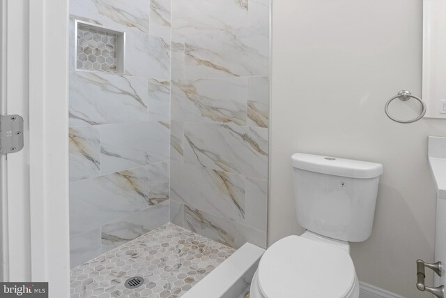 bathroom with toilet and a tile shower