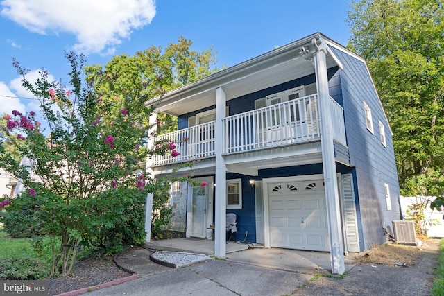 view of front of property with a balcony, central AC, and a garage