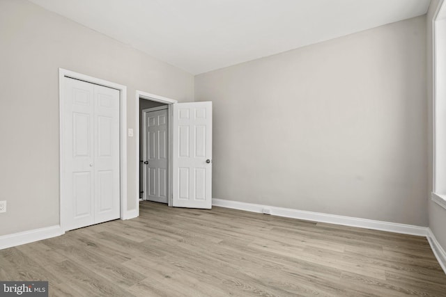 unfurnished bedroom featuring a closet and light hardwood / wood-style floors