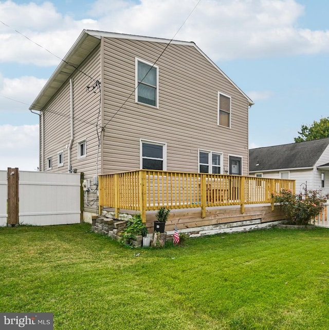 rear view of house with a deck and a yard