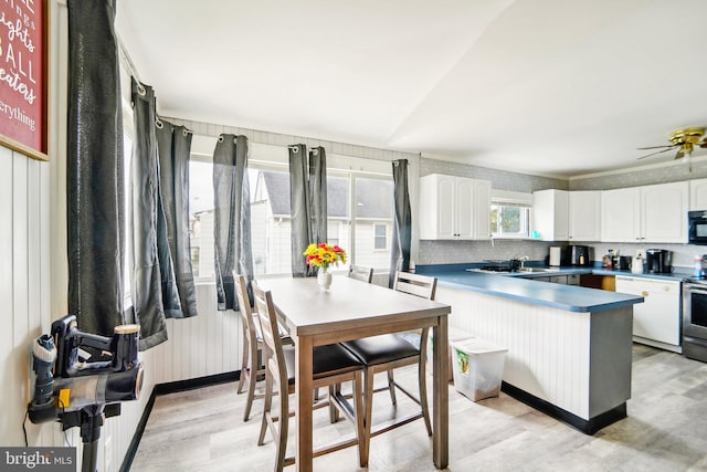 kitchen featuring backsplash, light wood-type flooring, white cabinetry, and stainless steel appliances