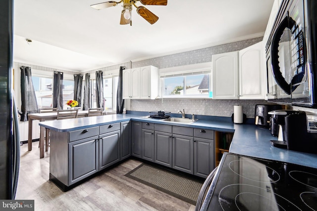 kitchen featuring gray cabinets, white cabinets, and a healthy amount of sunlight