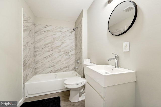 full bathroom featuring wood-type flooring, tiled shower / bath, vanity, and toilet