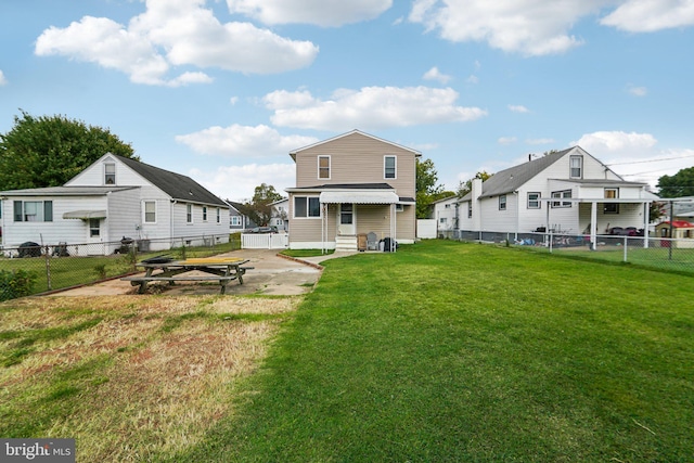 rear view of property featuring a lawn