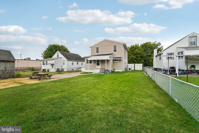 rear view of property featuring a lawn