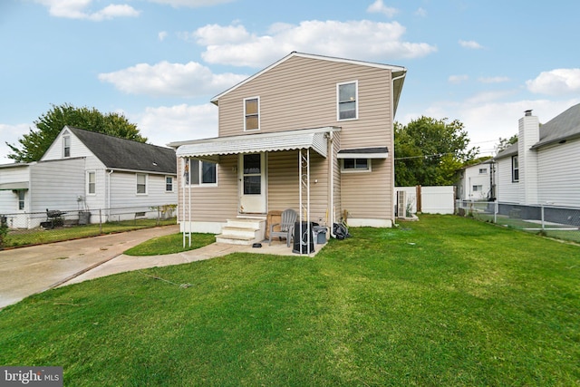 rear view of property with a lawn