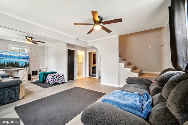 living room with light wood-type flooring, crown molding, and ceiling fan