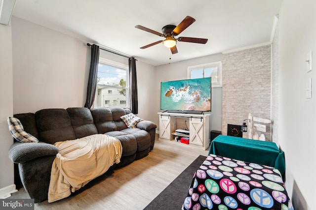 bedroom with a fireplace, ceiling fan, and light hardwood / wood-style flooring