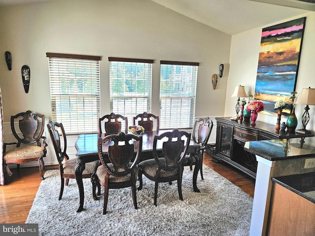 dining room featuring hardwood / wood-style floors and vaulted ceiling