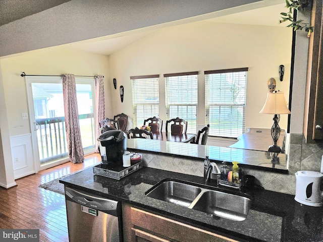 kitchen featuring a wealth of natural light, dishwasher, vaulted ceiling, and sink