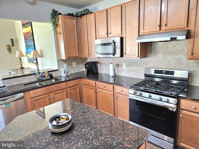 kitchen featuring dark stone countertops, appliances with stainless steel finishes, tasteful backsplash, and sink