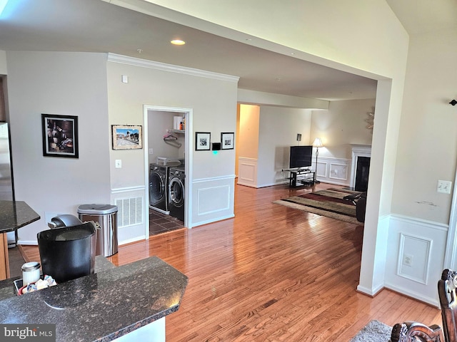 living room with crown molding, separate washer and dryer, and wood-type flooring