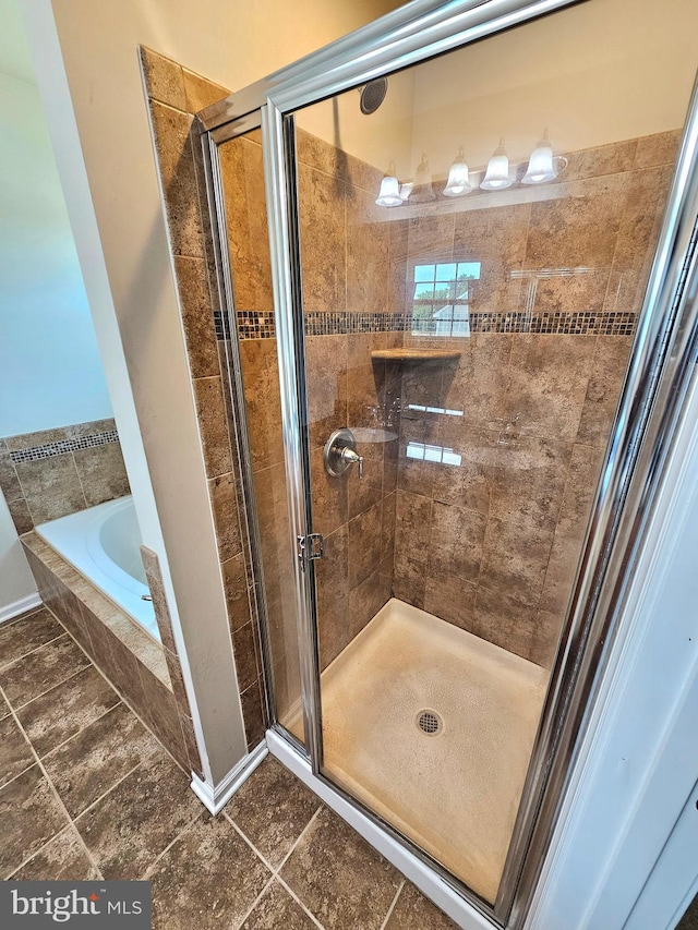 bathroom with tile patterned flooring and shower with separate bathtub