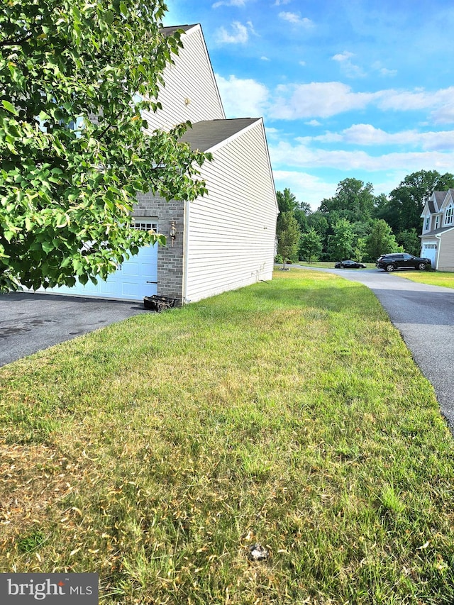 view of home's exterior featuring a yard and a garage