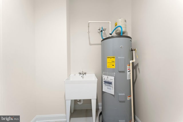 utility room with water heater and sink