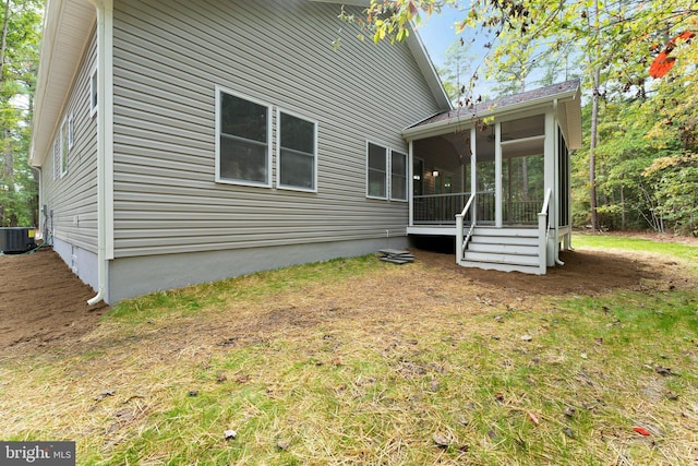 rear view of house featuring a sunroom and central AC