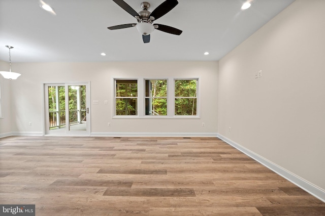 unfurnished room with a wealth of natural light, ceiling fan, and light wood-type flooring