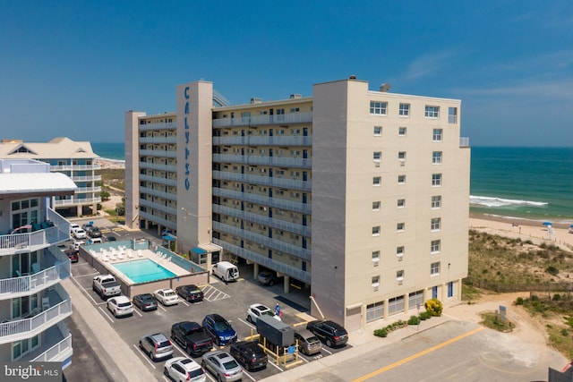 view of building exterior featuring a view of the beach and a water view