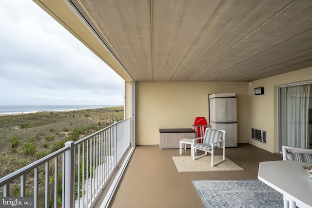 balcony featuring visible vents, radiator, and a water view