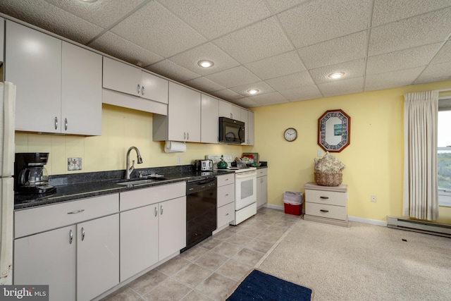 kitchen with a drop ceiling, black appliances, baseboard heating, sink, and white cabinets