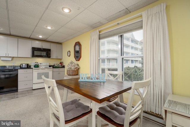 dining space featuring recessed lighting, a drop ceiling, baseboard heating, and light tile patterned floors