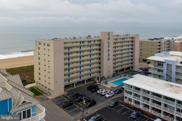 view of property with a view of city, a water view, and uncovered parking