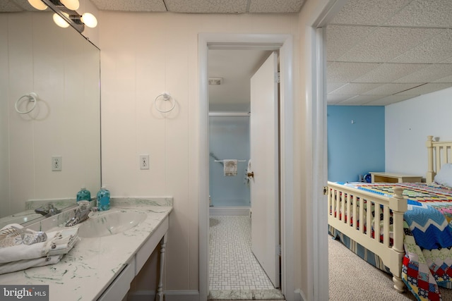 bathroom with a paneled ceiling and vanity