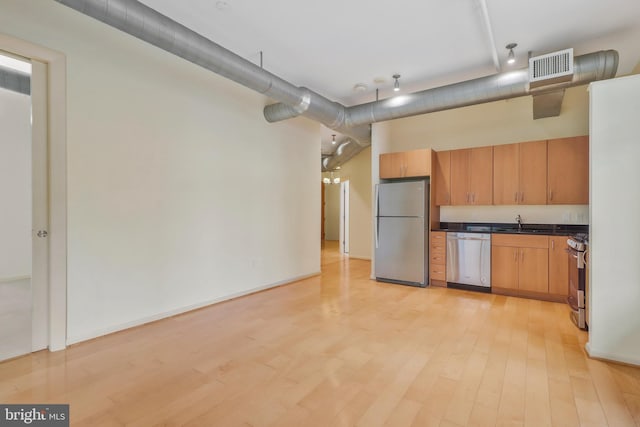 kitchen featuring light wood-type flooring, stainless steel appliances, and sink