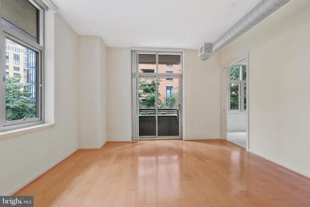 unfurnished room with plenty of natural light and light hardwood / wood-style flooring