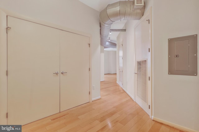 hallway with light wood-type flooring and electric panel