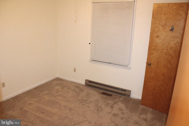 carpeted empty room with a baseboard heating unit and baseboards