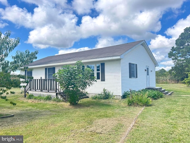 view of front facade with a deck and a front yard