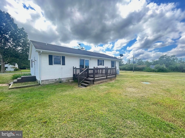 rear view of property with a yard and a wooden deck