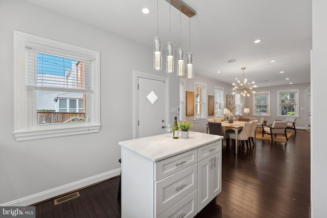 kitchen with hanging light fixtures, an inviting chandelier, white cabinets, and dark hardwood / wood-style floors