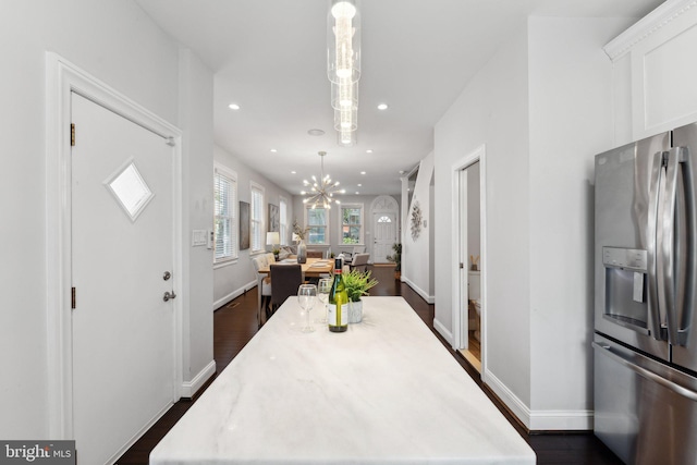 dining room with dark hardwood / wood-style floors and a notable chandelier