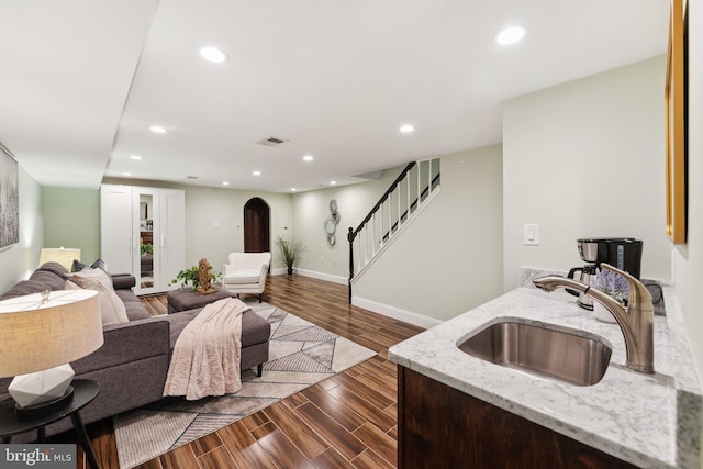 living room featuring dark wood-type flooring and sink