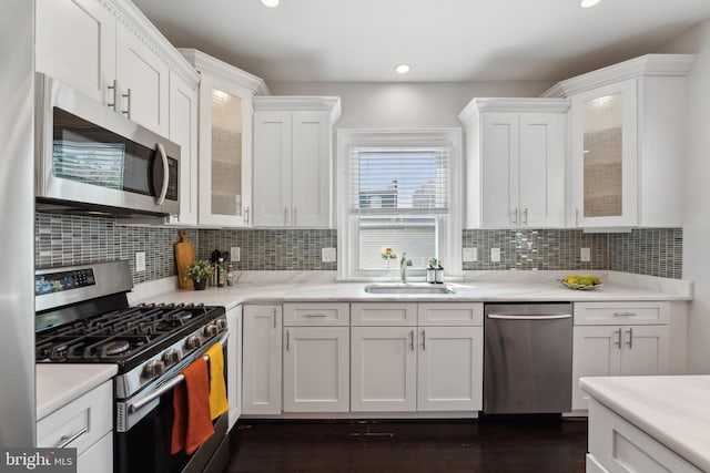 kitchen featuring white cabinets, stainless steel appliances, sink, dark hardwood / wood-style floors, and tasteful backsplash