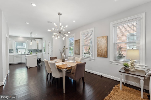 dining space with dark hardwood / wood-style floors and a chandelier