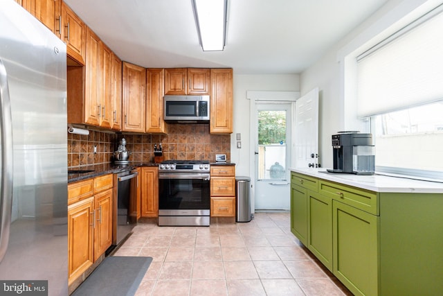 kitchen with light tile patterned flooring, stainless steel appliances, and backsplash