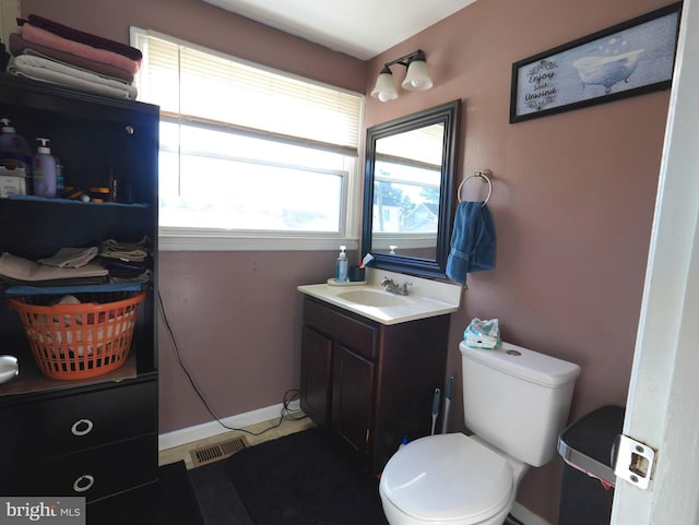 bathroom with vanity, toilet, and baseboards