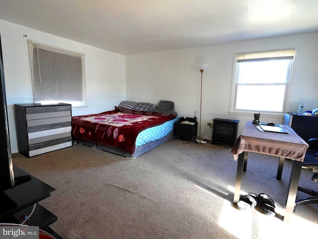 carpeted bedroom featuring a wood stove