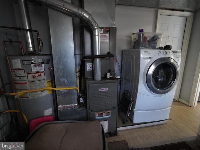 washroom with gas water heater, hardwood / wood-style floors, and washer / clothes dryer