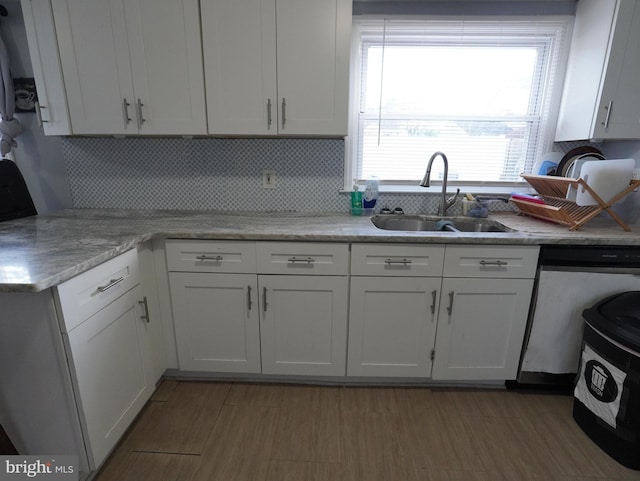 kitchen featuring light hardwood / wood-style flooring, sink, dishwasher, and white cabinets